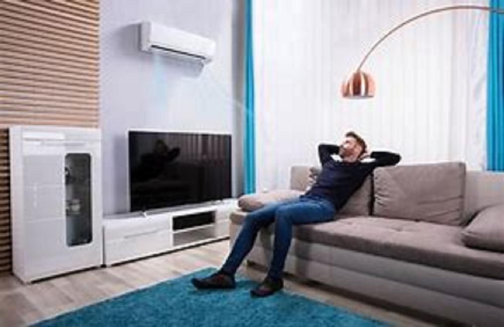 Soluciones Energéticas y Reformas, S.L. hombre en casa con equipo de aire acondicionado